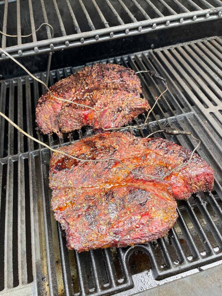 two chuck roasts on the smoker, about half way done.