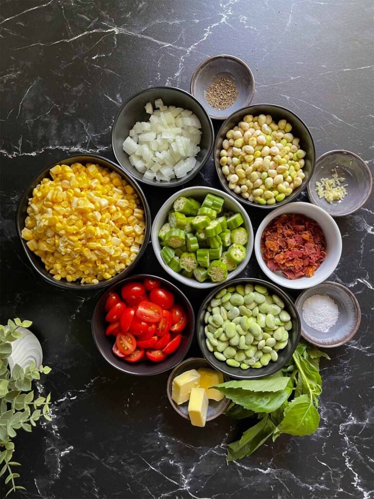 Summer succotash recipe ingredients on a dark surface.