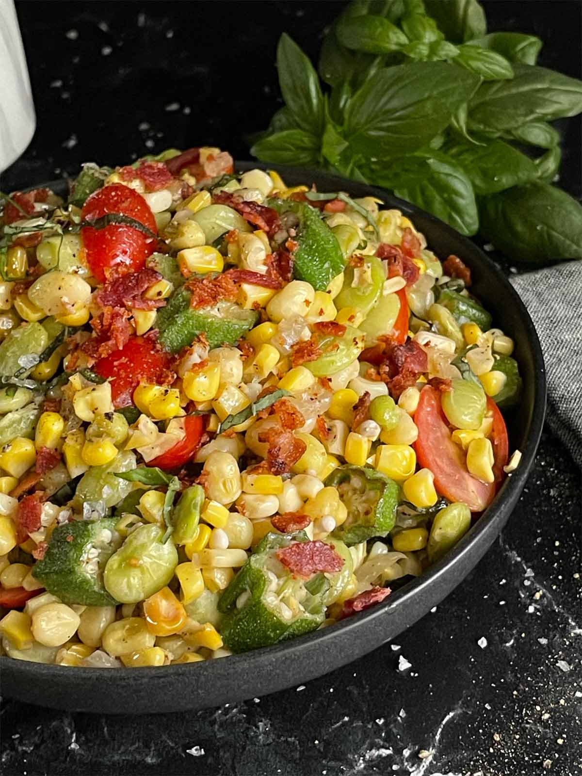 summer succotash vegetables in a round black bowl