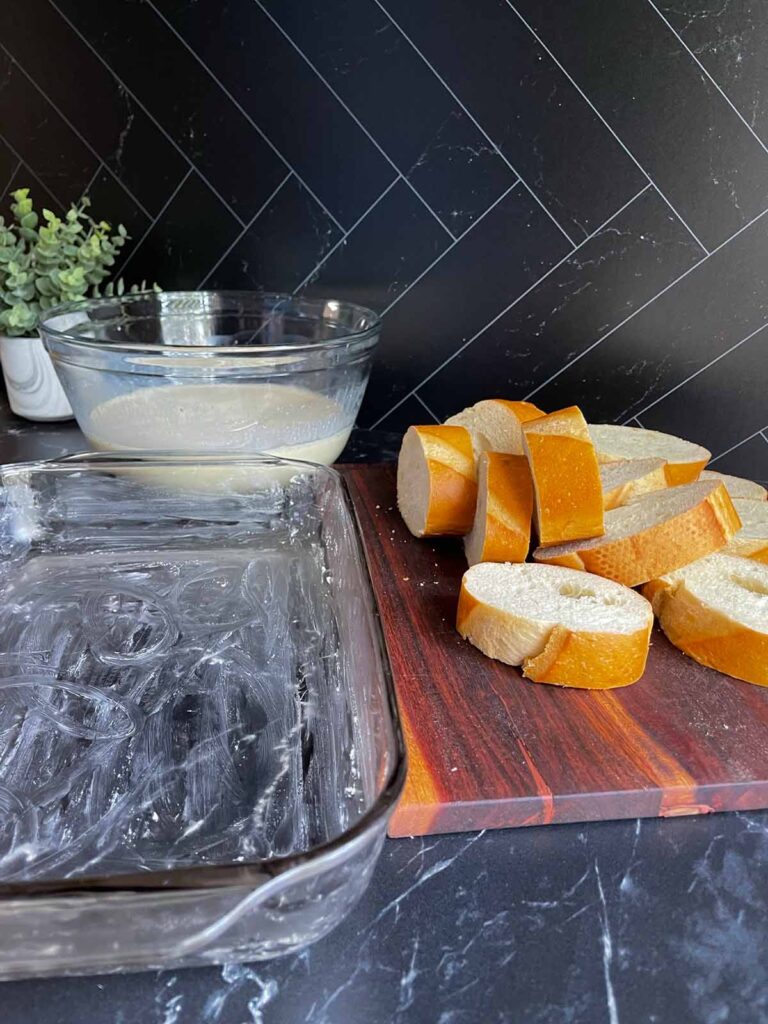 Sliced bread with a buttered baking dish.