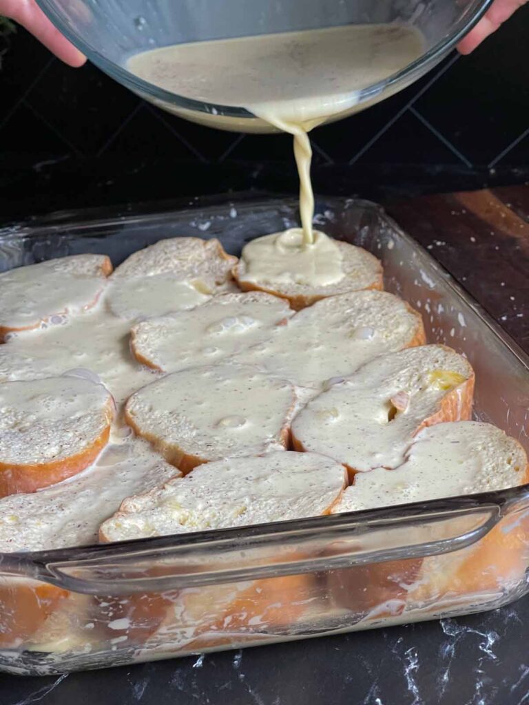 Pouring the remaining french toast mixture over the bread.