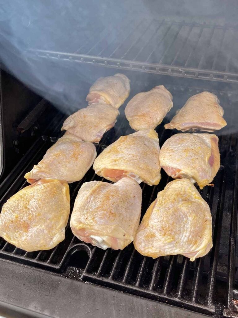 Chicken thighs just placed into a smoker.