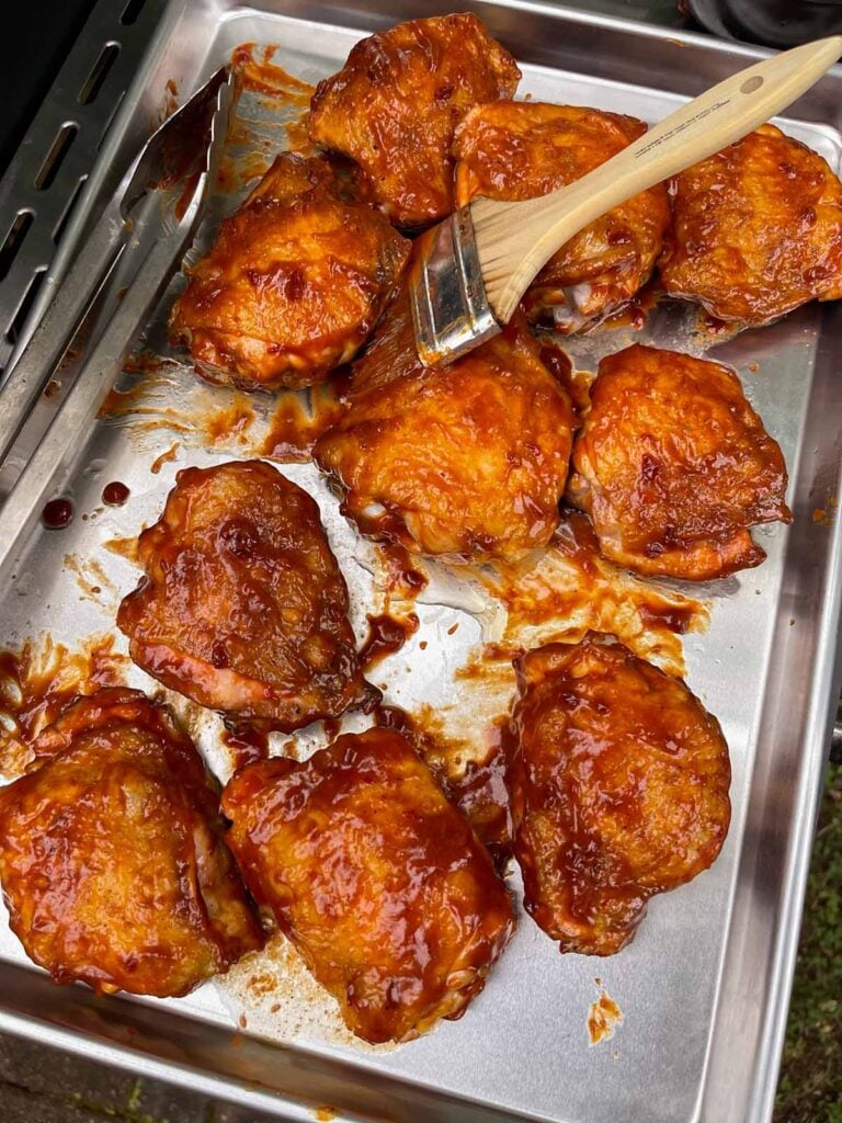 Chicken thighs with a layer of bbq sauce applied.