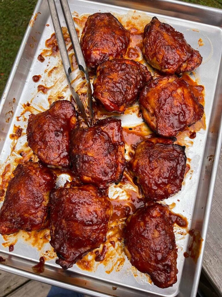 barbecued chicken recently pulled from the smoker on a baking sheet.