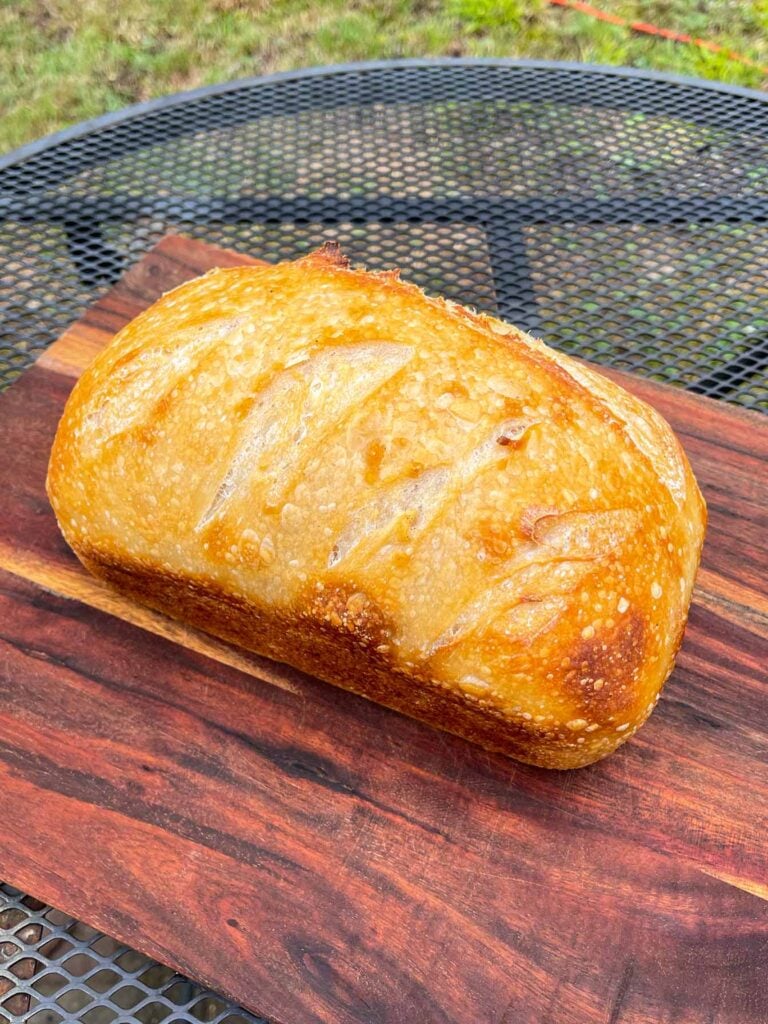 a loaf of sourdough on a wood cutting board