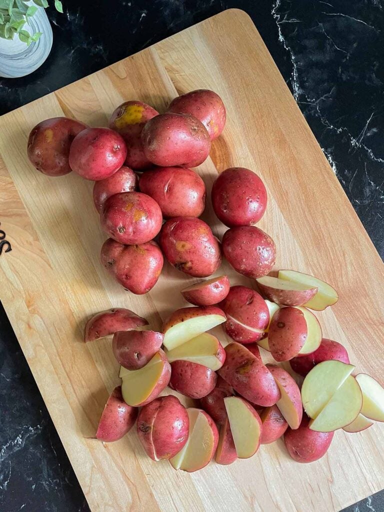 Cut red potatoes on a cutting board.