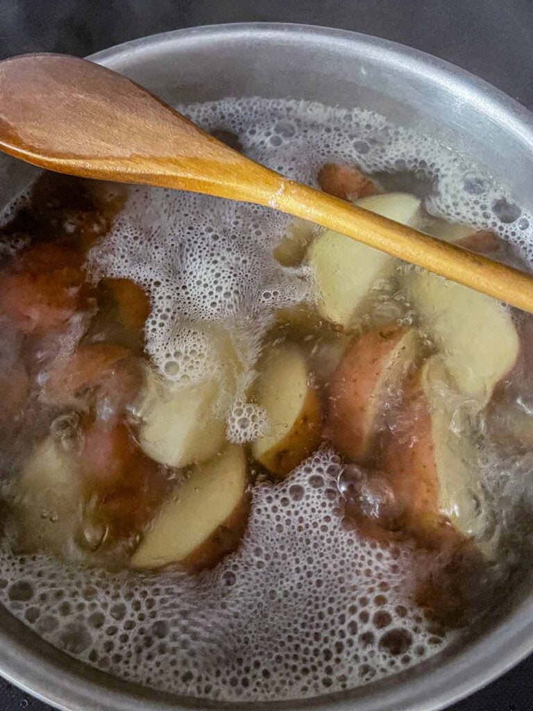 Red potatoes boiling on the stovetop.