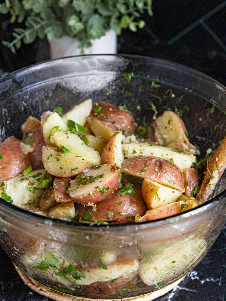 Herb potato salad in a glass bowl.