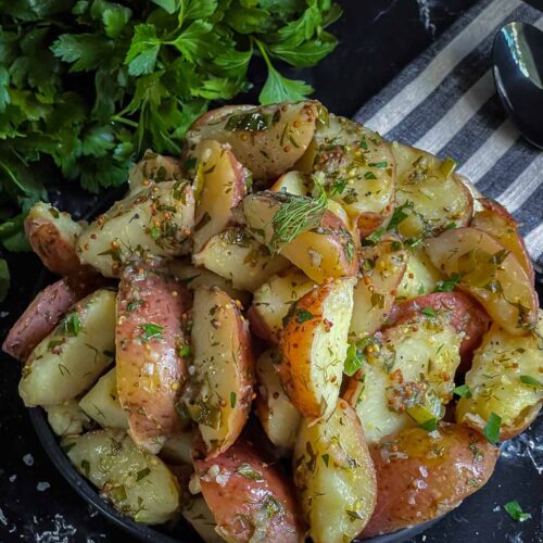 Herb potato salad in a black bowl.