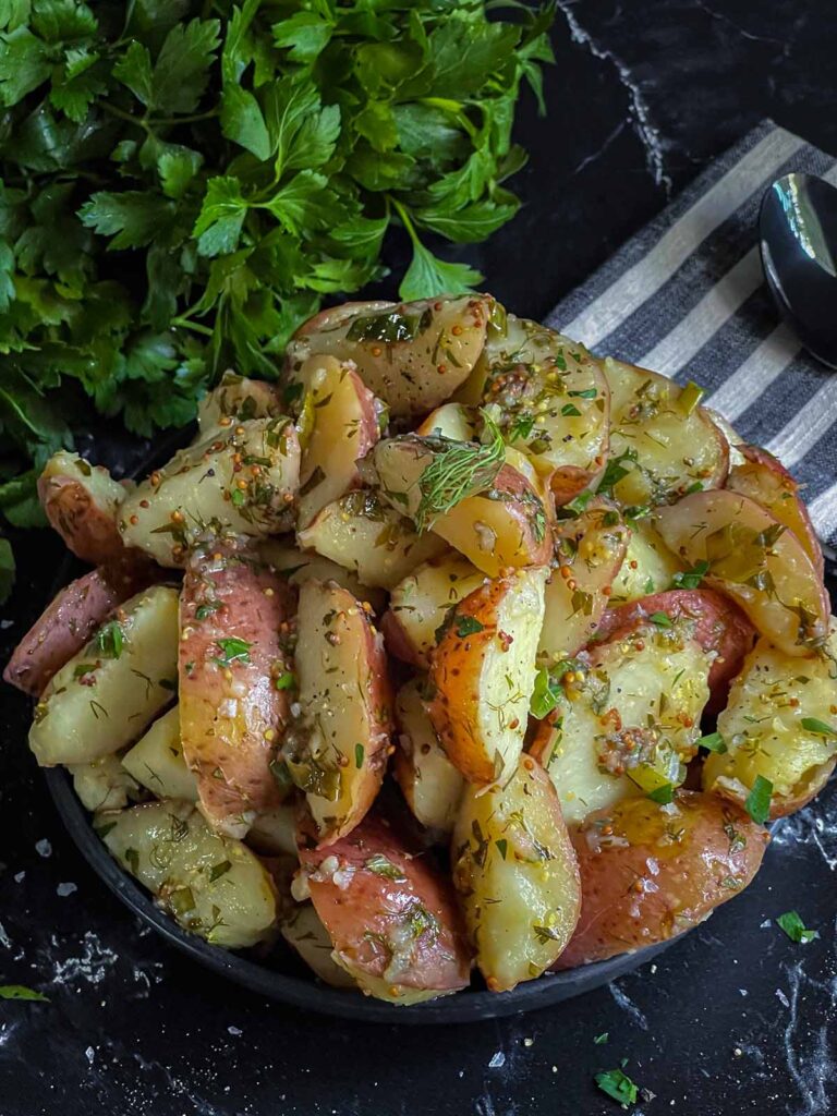 Herb potato salad in a black bowl.