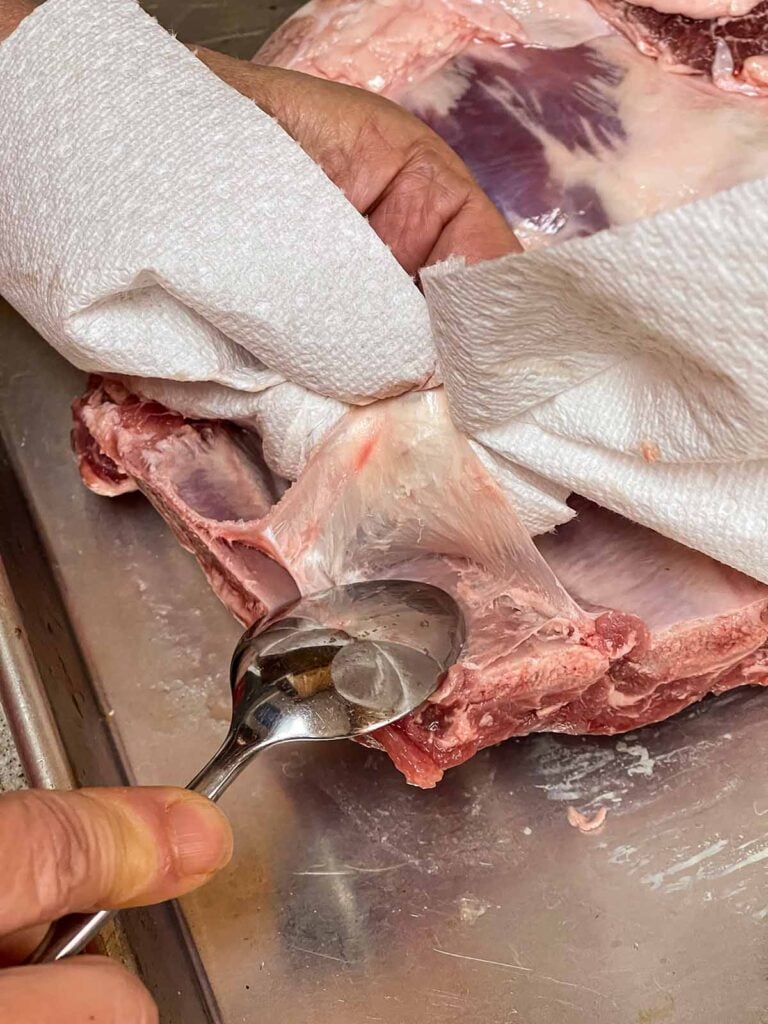 Removing the silver skin from a rack of ribs.