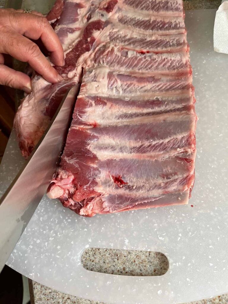 Removing the brisket bone and ribs tips from a rack of spare ribs.
