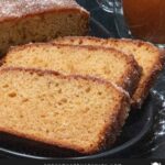 Apple cider doughnut cake on a black plate.