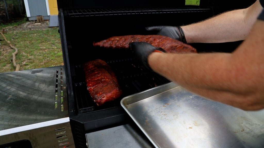 Removing the ribs from the Masterbuilt smoker after three hours of smoking.