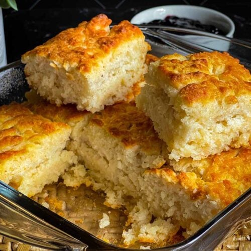 Two butter swim biscuits on top of the pan of biscuits.