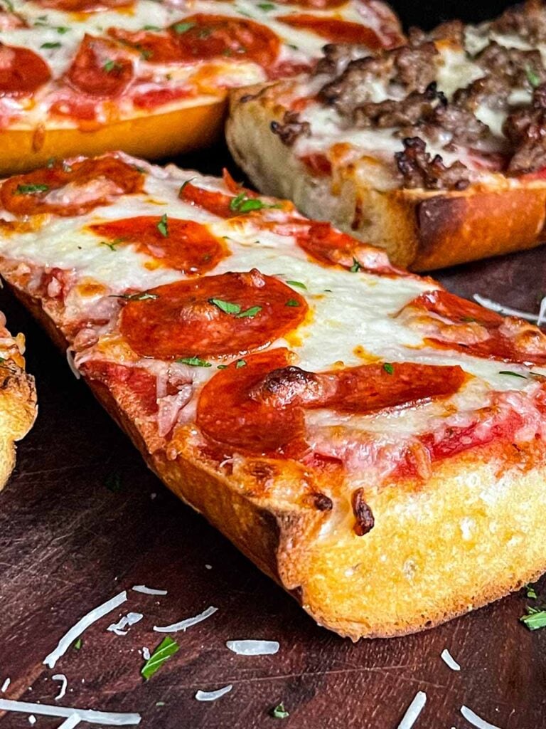 Pepperoni french bread pizza on a wooden cutting board.