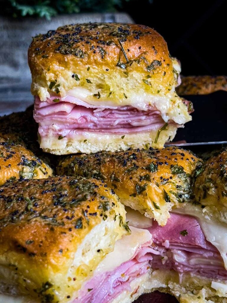 Ham and cheese sliders with one on top of th rest.