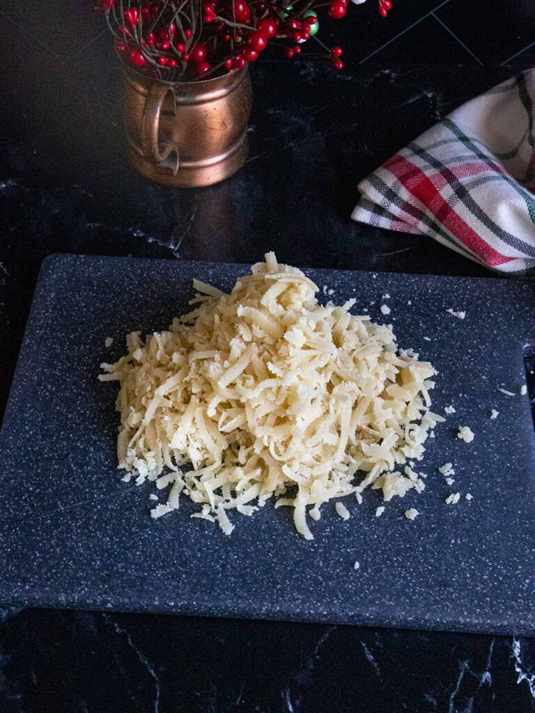 Shredded almond paste on a black cutting board.