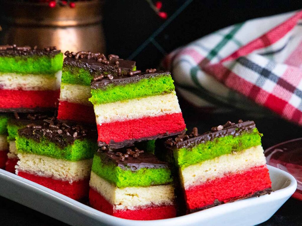 Italian rainbow cookies on a white tray.