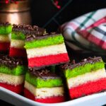 Italian rainbow cookies on a white tray.