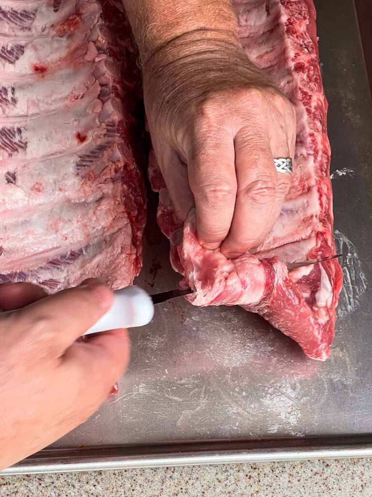 Trimming the ribs so little bits and pieces don't get burnt up in the smoking process.