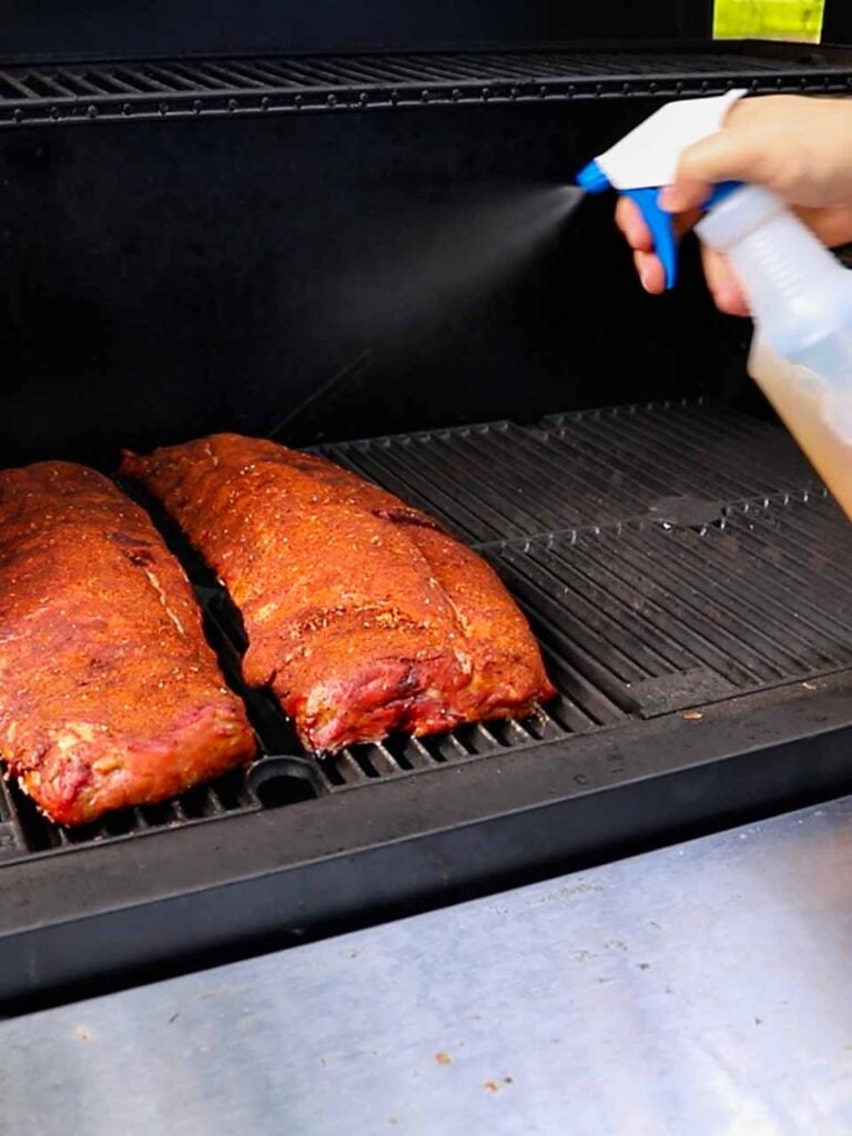 Spritzing the ribs with an apple cider vinegar and water mixture.