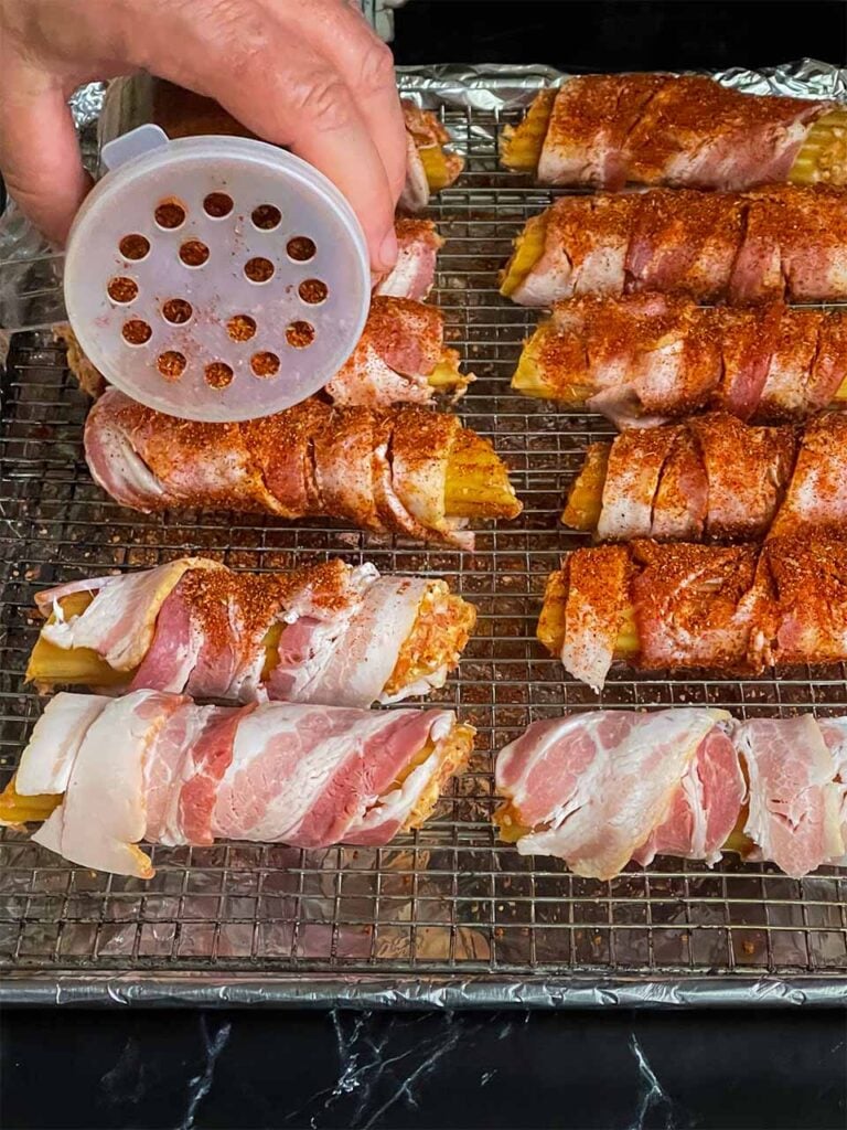 Covering the stuffed shells with barbecue rub.