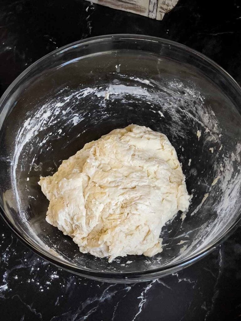 Focaccia dough just mixed together in a glass bowl.