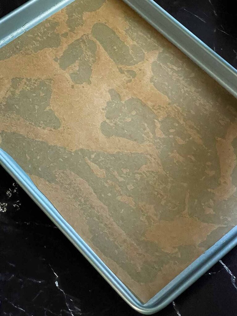 A sheet of parchment paper on an oil lined baking sheet.