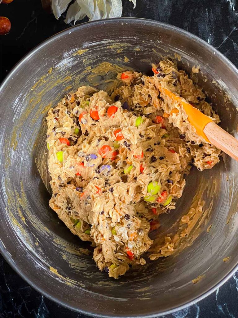 Halloween monster cookie dough in a metal mixing bowl.