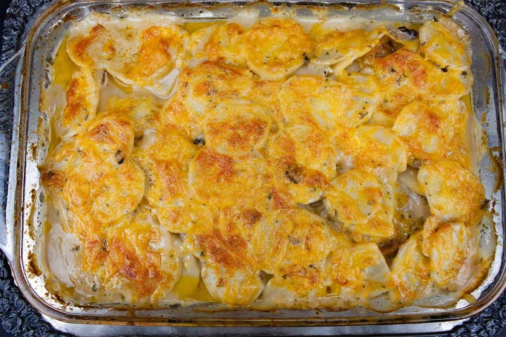 Smothered porkchops with potatoes in a glass cooking dish.