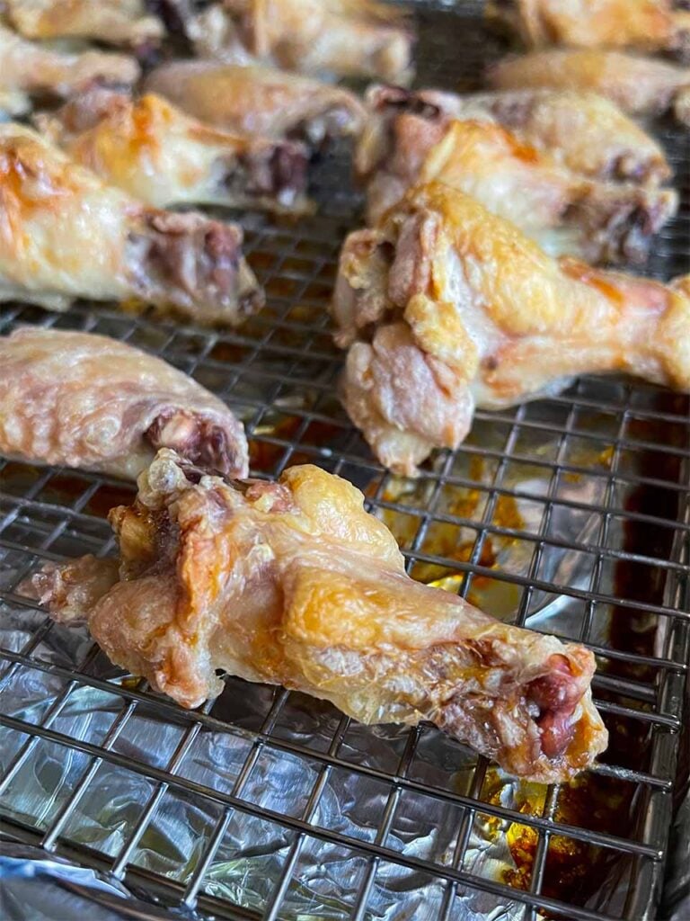 Baked chicken wings on a wire rack.