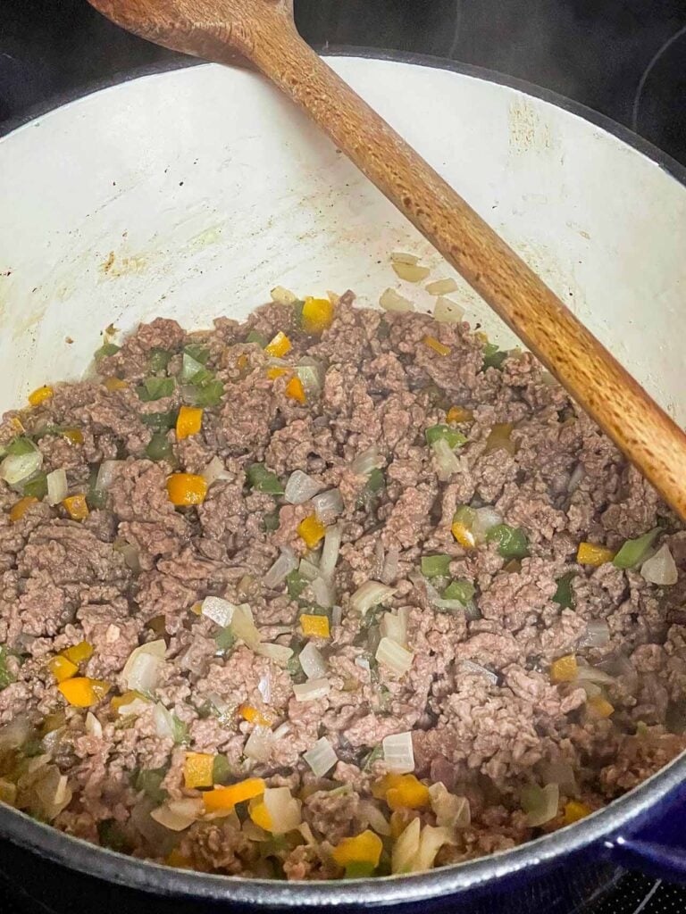 Browned ground beef with other spices in a large dutch oven.