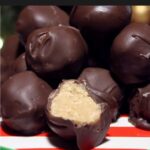 Peanut butter balls stacked on a red and green plate.