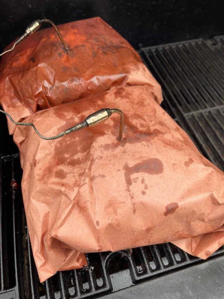 Smoked Pork Shoulder - This recipe and method produces a juicy, tender, perfectly smoked pork butt/shoulder EVERY TIME! Two pork butts wrapped in butcher paper on the smoker.