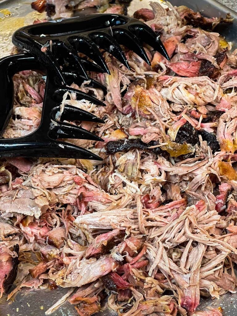 Pork shoulder meat shredded with a pair of meat claws.
