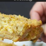 A slice of southern cornbread dressing lifted over the baking pan.