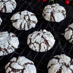 Chocolate crinkle cookies on a wire rack.