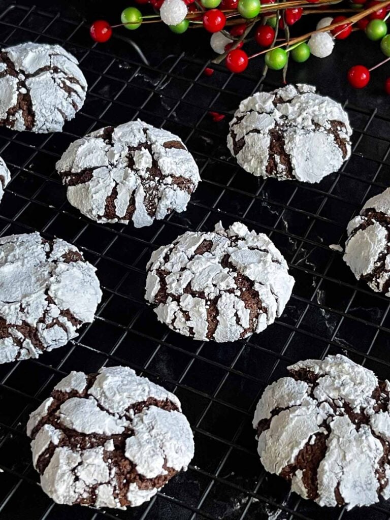 Chocolate crinkle cookies on a wire rack.