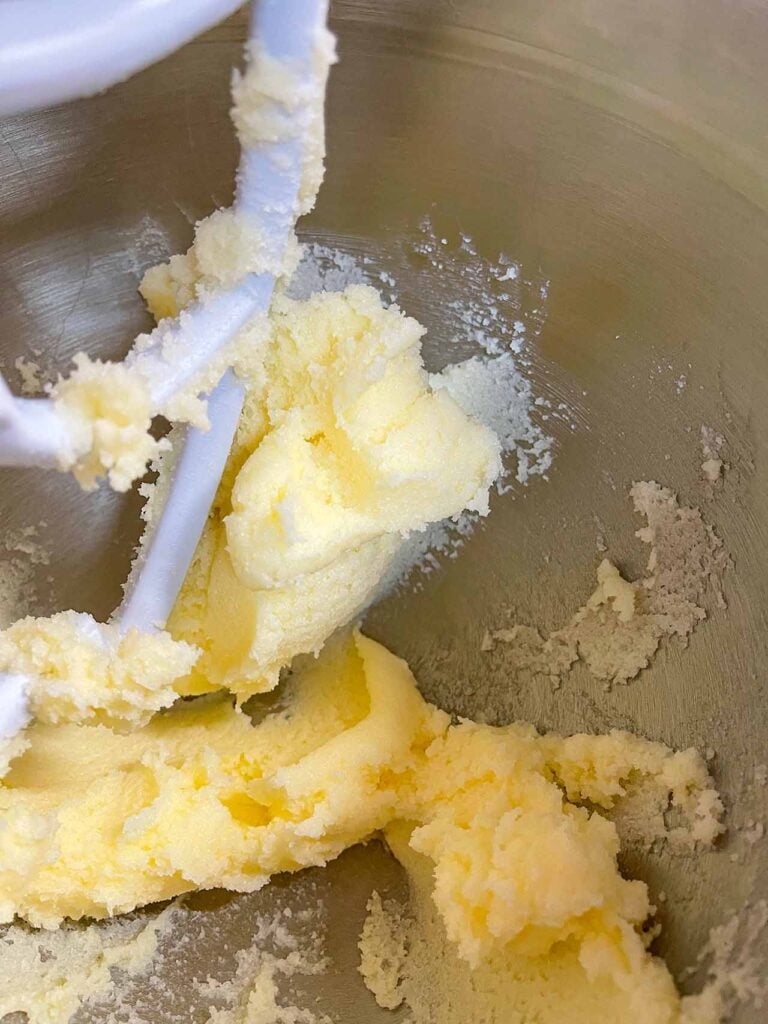 Butter and sugar creamed in a metal mixing bowl.