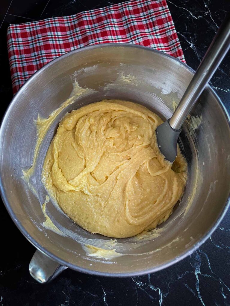 Eggnog bundt cake batter in a metal mixing bowl.