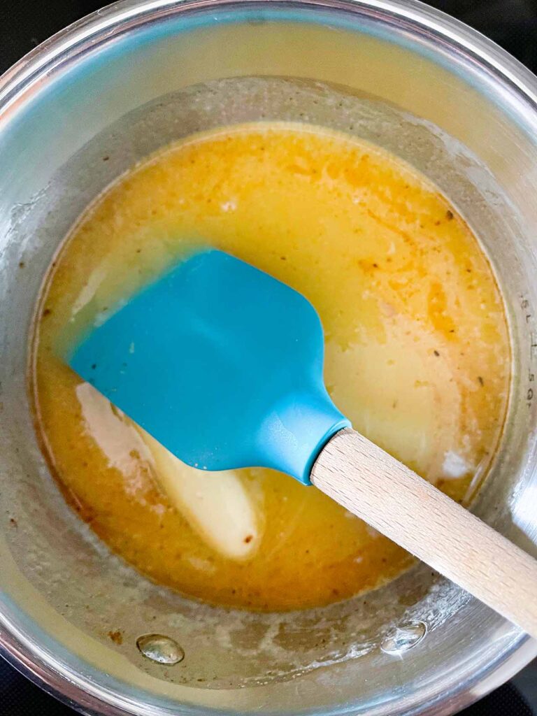 Eggnog glaze in a metal saucepan.