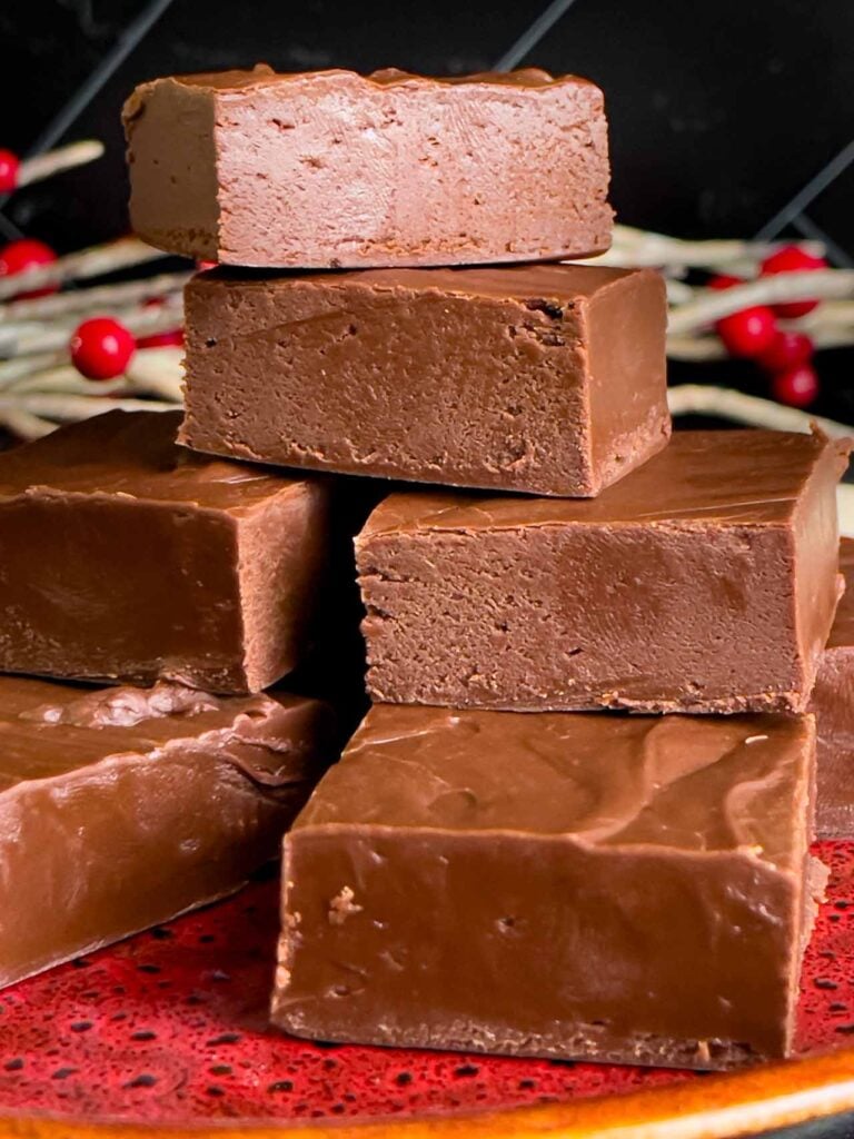 Extra dark chocolate fudge pieces stacked on a plate.