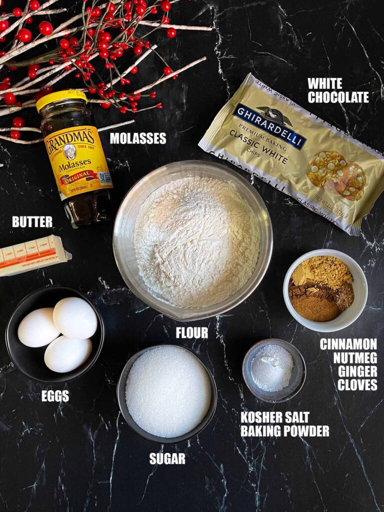 Ingredients for gingerbread biscotti on a dark surface.