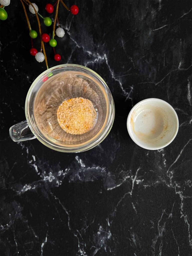 Holiday spice flat white spice mixture in the bottom of a glass coffee mug.