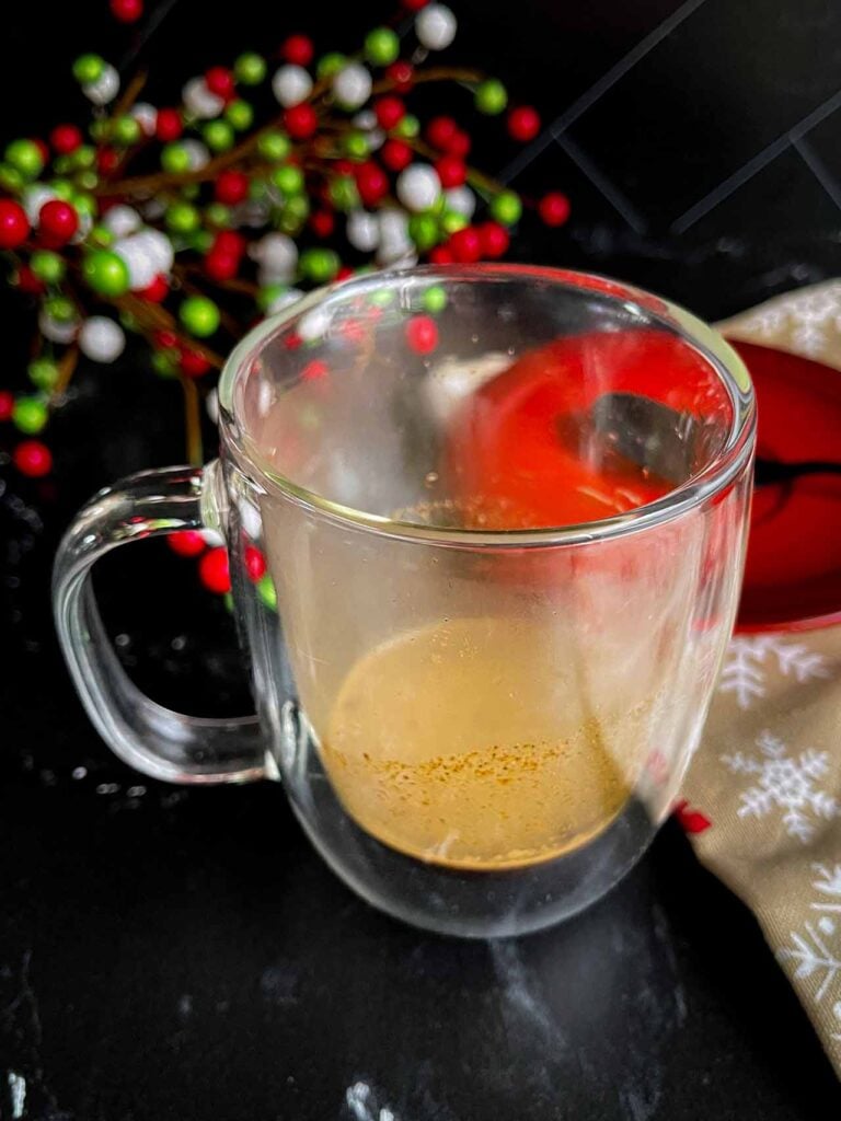 Espresso shot pulled over the holiday spice flat white spice mixture in the glass mug.