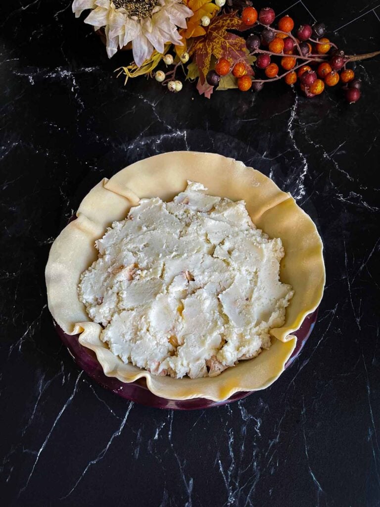 Mashed potatoes topping diced turkey in a pie crust.
