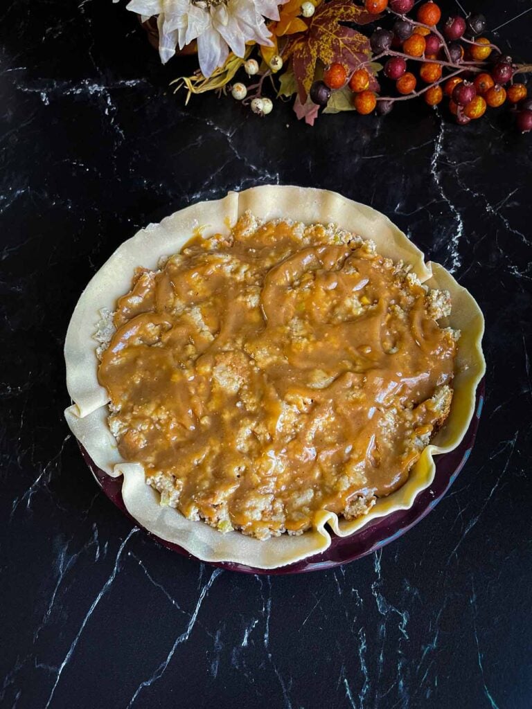 Gravy topping layers of Thanksgiving leftovers in a pie crust.