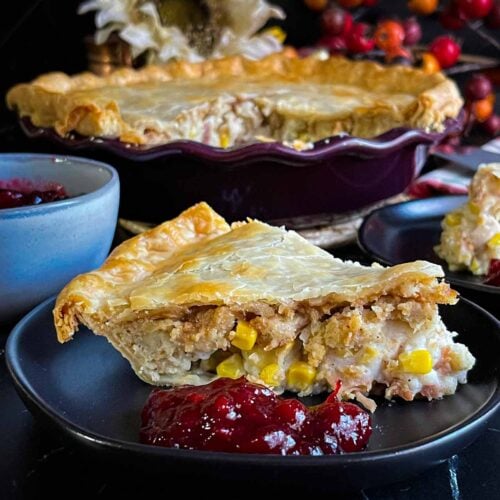 A slice of leftover Thanksgiving pie on a black plate.