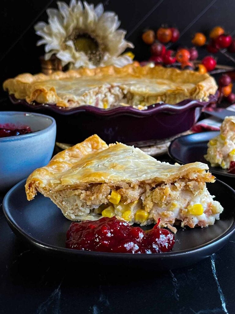 A slice of Thanksgiving pie on a black plate.